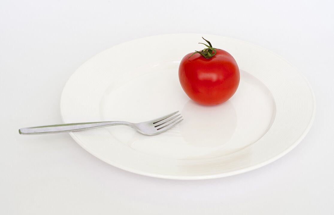помидор вилкой на тарелке